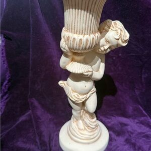 This item is a vintage figurine candle holder or planter featuring a cherub